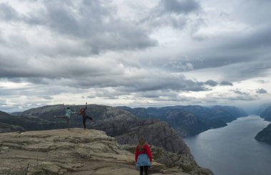 Songesand, Norveç, 9 Eylül 2019: Bir grup turist güzel manzaraya hayran kalıyor ve Fiyort Lysefjord 'daki Preikestolen uçurumunda poz veriyor. Huysuz bir sonbahar günü. Tatil ve yürüyüş tatili