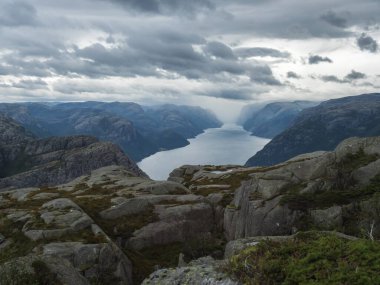 Kayalar, bluzlar, taşlar ve Lysefjord 'la Preikestolen devasa uçurumlarına yürüyüş yaparken manzarayı seyret. Norveç' in ünlü manzarası Moody, sonbahar günü. Doğa ve seyahat geçmişi, tatil ve yürüyüş tatili