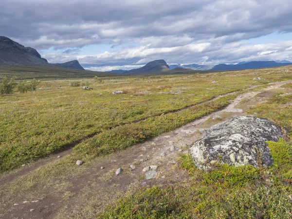Lapland landschap met Kungsleden wandelpad bij Saltoluokta, Zweden. Wilde natuur met besneeuwde bergen, herfstkleurige struiken, berkenbomen en heide. Blauwe lucht witte wolken — Stockfoto