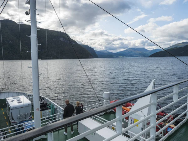 Valldal, norwegen, 7. september 2019: junges paar an Bord der fähre nach geiranger. Frau beim Fotografieren von Fjord. Blick über den Storfjord, Richtung Dorf eidsdal. Sommer, blauer Himmel. Norwegen — Stockfoto