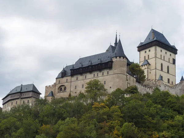 Aus nächster Nähe die gotische Burg Karlstejn in der Nähe von Prag, die berühmteste Burg der Tschechischen Republik mit herbstlichen Bäumen. blauer Himmel Wolken Hintergrund. in der Nähe von Prag. — Stockfoto