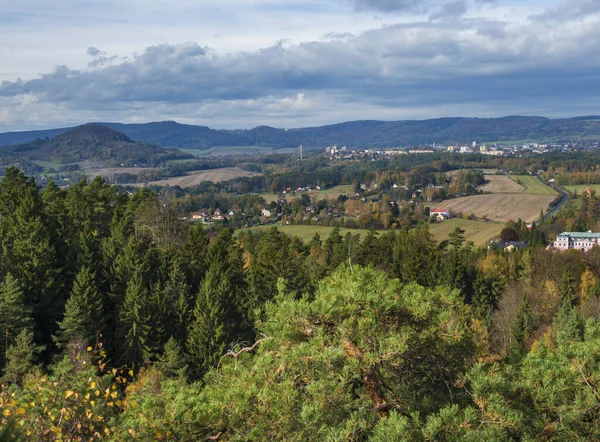 Vista desde el mirador de Hrabencina vyhlidka en la ciudad de Novy bor en luzicke hory, montañas de Lusacia con bosque de árboles de coníferas y caducifolios de color otoñal y colinas verdes, cielo azul, nubes blancas — Foto de Stock