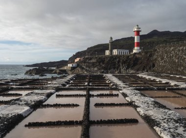 Fuencaliente salinas ya da tuzhane manzarası ve iki deniz feneri, eski taş ve beyaz çizgili volkanik kaya tarlası. La Palma, Kanarya Adaları. Okyanus, mavi gökyüzü beyaz bulutlar.