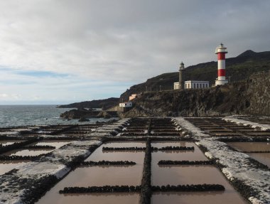 Fuencaliente salinas ya da tuzhane manzarası ve iki deniz feneri, eski taş ve beyaz çizgili volkanik kaya tarlası. La Palma, Kanarya Adaları. Okyanus, mavi gökyüzü beyaz bulutlar.