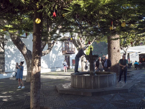 Las Nieves, La Palma, Canary Island, Ισπανία, 19 Δεκεμβρίου 2019: Τουριστικοί και ντόπιοι στο μπαρόκ σιντριβάνι με την εκκλησία Santuario de Nuestra Senora de las Nieves και φοίνικα με τα Χριστούγεννα — Φωτογραφία Αρχείου