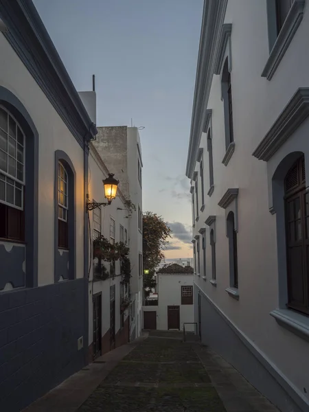 Gece, Santa Cruz de la Palma şehir merkezinde parlayan fener, mavi beyaz geleneksel evler ve kaldırım taşları olan boş dar bir sokak. La Palma, Kanarya Adaları, İspanya — Stok fotoğraf