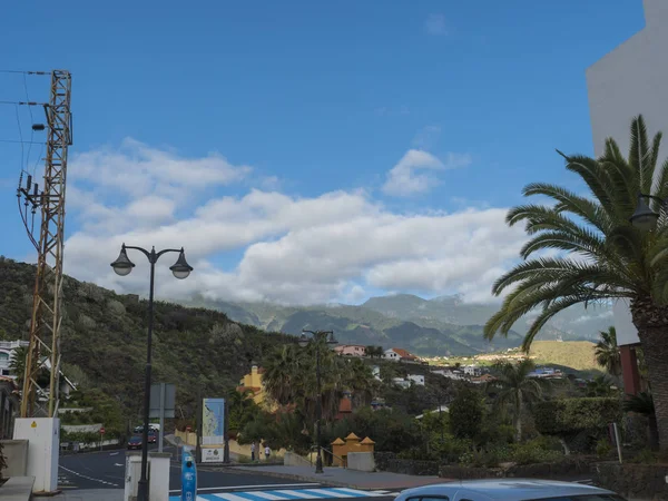ロス・カンカホス、ラ・パルマ、カナリア諸島、スペイン、 2019年12月22日:緑の山々と丘、駐車場、ヤシの木を望むロス・カンカホスのメインストリート — ストック写真