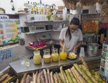 Santa Cruz de la Palma, La Palma, Kanarya Adaları, İspanya, 23 Aralık 2019: Belediye binasında narenciye ve şeker kamışından taze meyve suyu ve kokteyl hazırlayan genç kadın