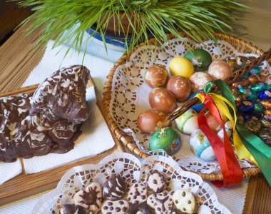 Çek Cumhuriyeti, Prag, 22 Nisan 2019: Hasır sepette ev yapımı renkli paskalya yumurtaları, paskalya kurabiyeleri, Pomlazka - geleneksel örülmüş kırbaç.