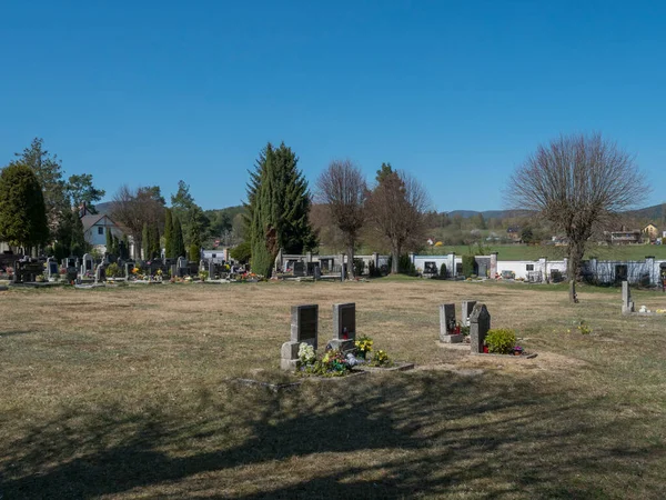 Czech Republic, Cvikov, April 19, 2020: old village cemetery or churchyard with 19th century graves In Cvikov, Lusatian mountains, early spring green landscape in background — Stock Photo, Image
