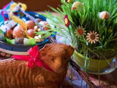 Homemade Paschal lamb cake and Colorful Painted easter eggs and Pomlazka - traditional braided whip from pussy willow and decorated green sprouts, selective focus.