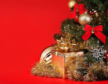 Noel. Hediye kutusu kırmızı bir arka plan üzerinde Noel ağacı altında