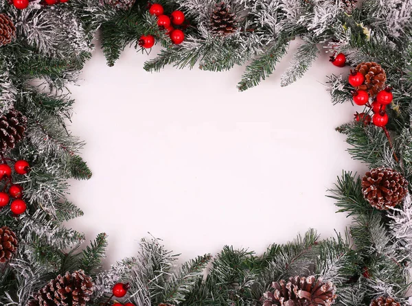 Kerst decoratieve rand met denneappels en holly bessen — Stockfoto