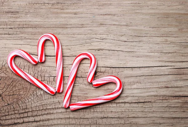 Peppermint Candy Canes in Heart Shapes on wooden background. Chr — Stock Photo, Image