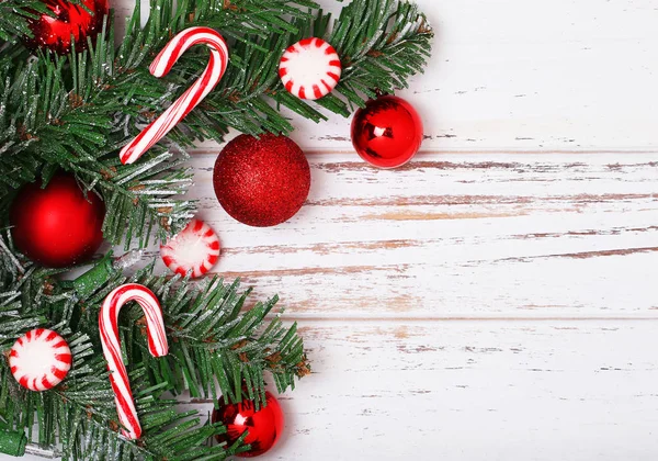 Rama de árbol de Navidad con bolas rojas y cono de caramelo —  Fotos de Stock