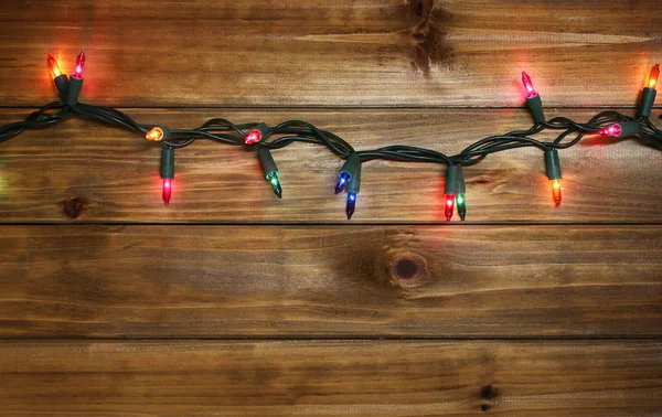 Natal ou Ano Novo luzes no fundo de madeira — Fotografia de Stock