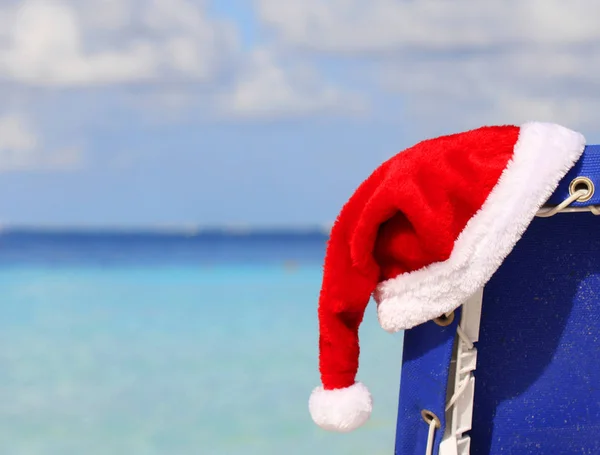 Santa's Hat on chair lounge on tropical caribbean beach — Stock Photo, Image