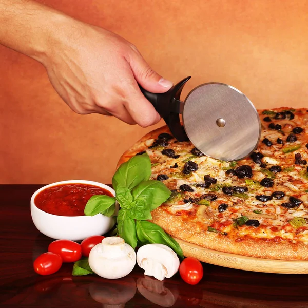 Резание итальянской овощной пиццы с овощами — стоковое фото