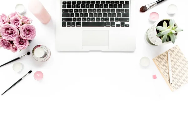 オフィス テーブル デスク。ラップトップ、コンピューター。雑誌、ソーシャル メディア。平面図です。フラットが横たわっていた。ホーム オフィスのワークスペースです。女性のファッション。バラの花束は、ノートブック、白い背景の上。ツールのメイクブラシ — ストック写真
