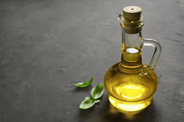 Olive oil in bottle and fresh basil — Stock Photo, Image