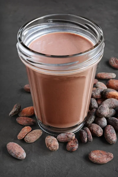 Chocolate milk and pieces of chocolate bar and cocoa beans — Stok Foto