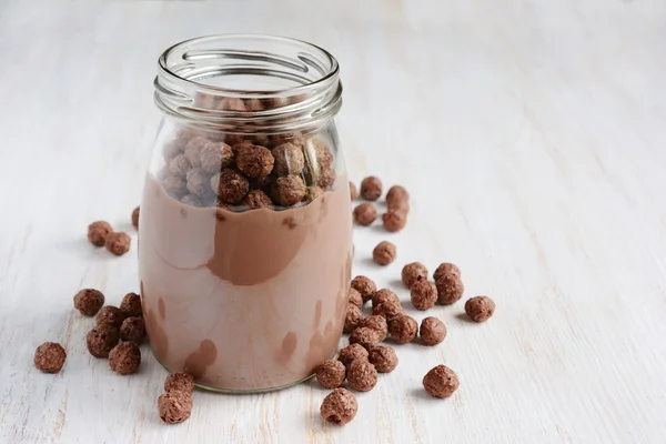 Chocolate milk with chocolate cereal balls in a glass jar — Stock Photo, Image
