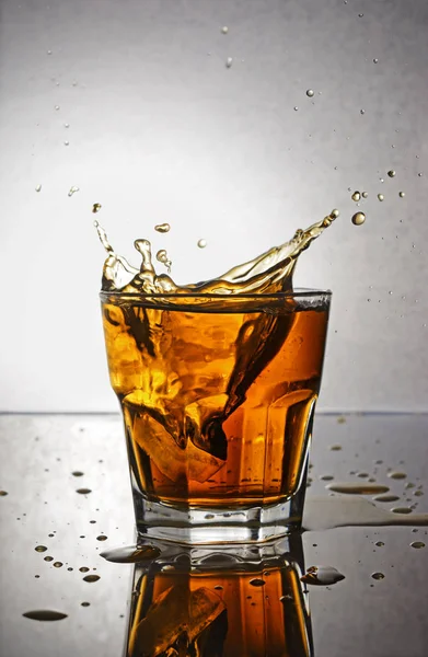 Splash in glass of scotch whiskey with ice — Stock Photo, Image