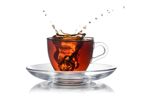 Salpicar en taza de vidrio de té negro con hielo — Foto de Stock