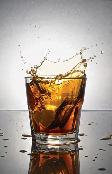 Plons in glas van scotch whisky met ijs — Stockfoto