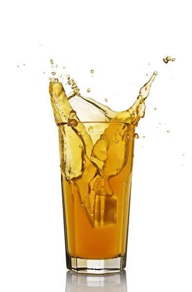 Salpicadura en un vaso de jugo de naranja con hielo — Foto de Stock
