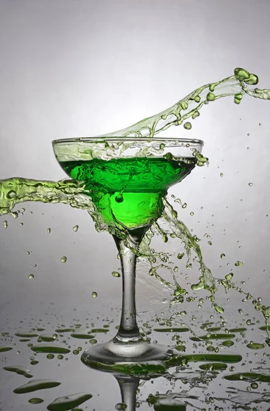Stänk i glas grön cocktail alkoholdryck — Stockfoto