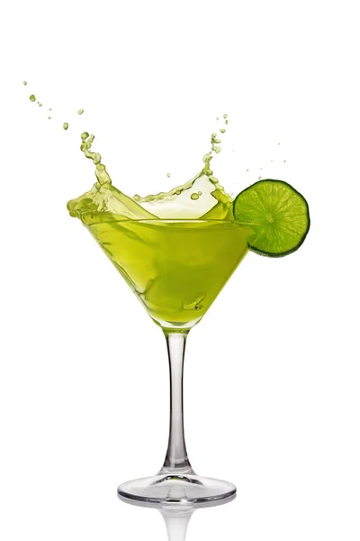 Splash in glass of green alcoholic cocktail drink with lime — Stock Photo, Image