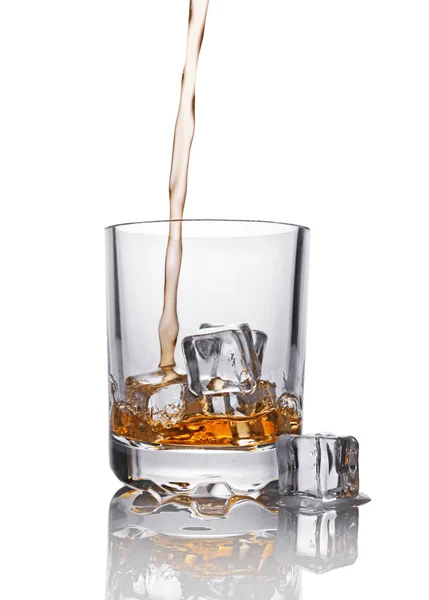 Gieten van scotch whisky in glas met ijsblokje — Stockfoto