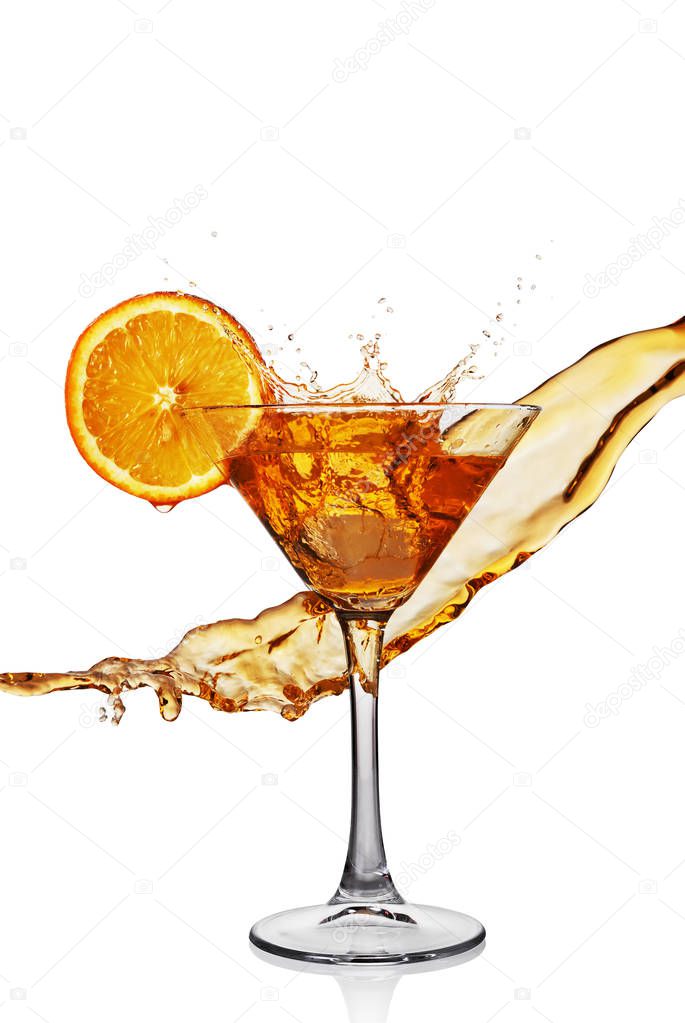 Splash in glass of transparent alcoholic cocktail drink with slice orange and ice