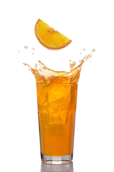 Splash in glass of juice with falling slice of orange — Stock Photo, Image