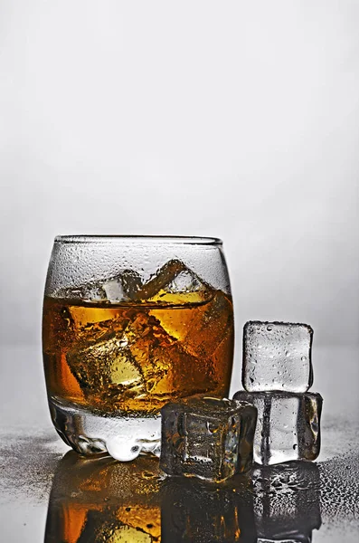 Glas van scotch whisky met ijsblokje — Stockfoto