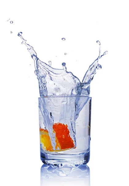 Spritzer in einem Glas blauen Wassers mit Orangenscheibe — Stockfoto