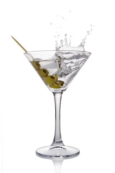 Брызги в бокале белого прозрачного алкогольного коктейля с оливками — стоковое фото