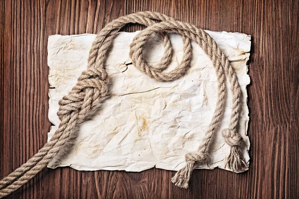 Крупный план морского узла веревки на желтой ретро-окрашенной бумаге — стоковое фото
