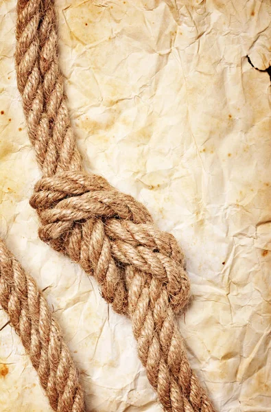 Крупный план морского узла веревки на ретро-бумаге — стоковое фото