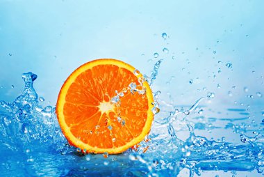 Juicy yarım portakal mavi su sıçrama