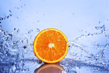 Juicy yarım portakal mavi su sıçrama