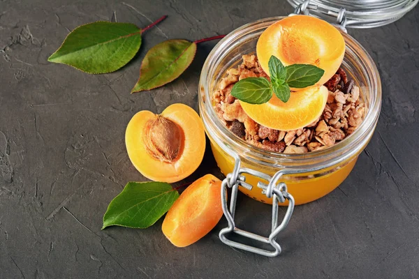 Gezond ontbijt. Zelfgemaakte muesli met gelei en verse abrikoos in glazen pot — Stockfoto