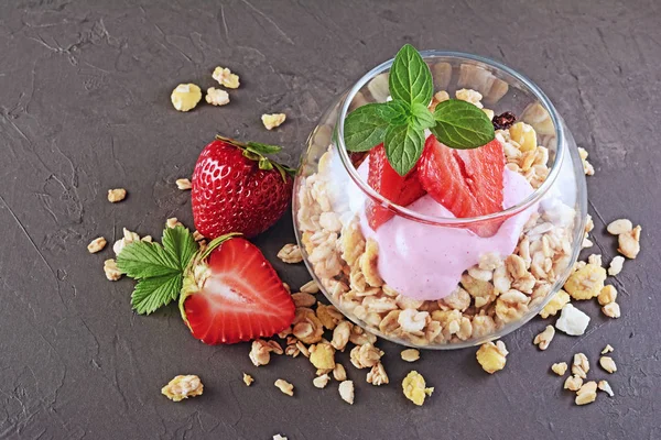 Gezond ontbijt. Zelfgemaakte muesli en yoghurt met verse aardbeien en munt in glas — Stockfoto
