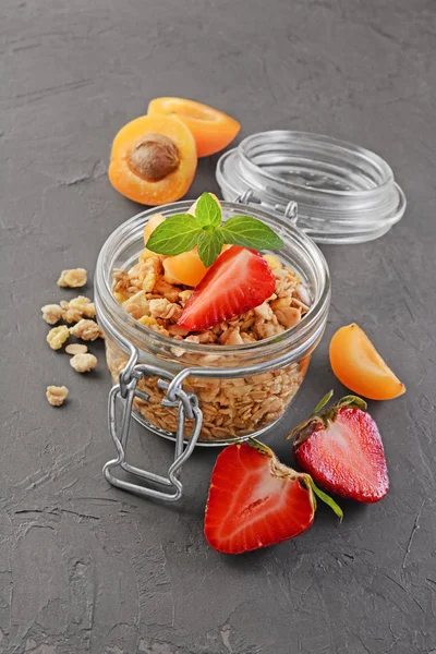 Healthy breakfast. Homemade granola in glass jar with fresh strawberry, apricot and mint — Stock Photo, Image