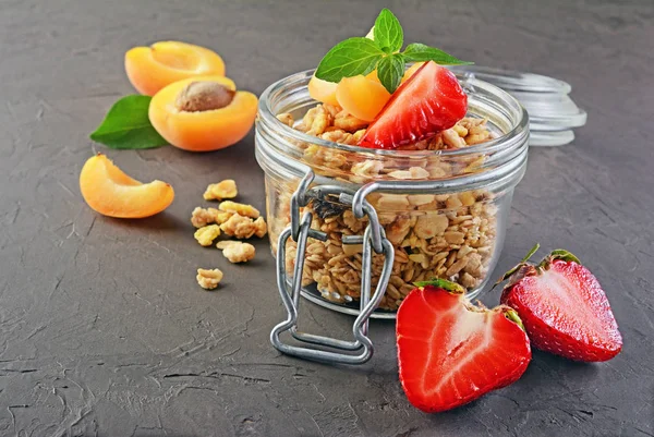 Healthy breakfast. Homemade granola in glass jar with fresh strawberry, apricot and mint — Stock Photo, Image