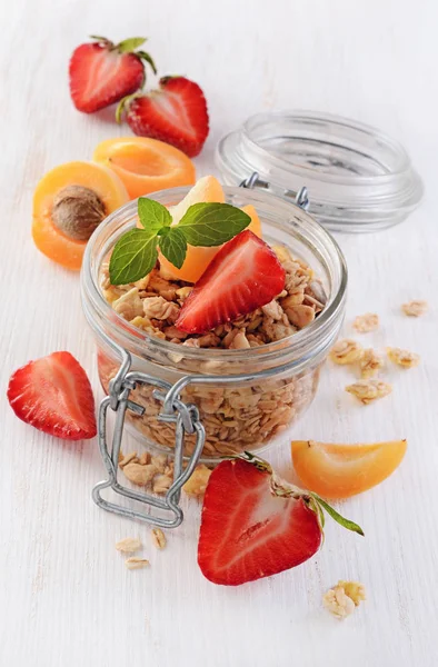 Healthy breakfast. Homemade granola in glass jar with fresh strawberry, apricot and mint — Stock Photo, Image