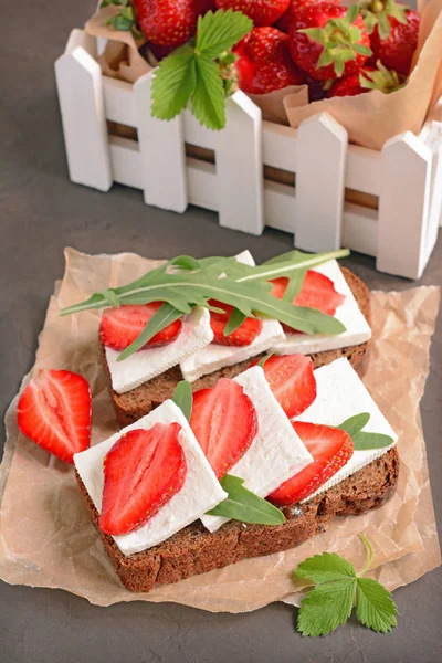 Sandwich santé avec pain de seigle, fraise fraîche, roquette et fromage à pâte molle sur parchemin — Photo