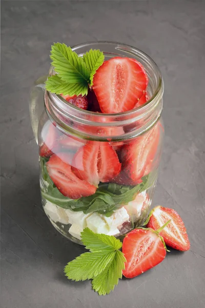健康的沙拉菜与新鲜的草莓、 芝麻菜和软奶酪在玻璃罐里 — 图库照片