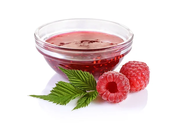 Close up view jam in glass bowl with fresh ripe raspberry and leaves — Stock Photo, Image
